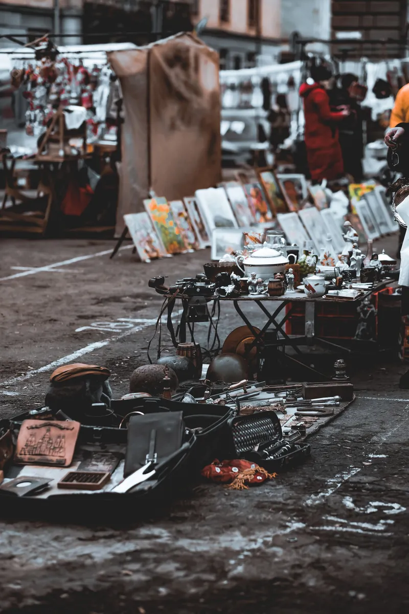 Flea market tables spread with vintage cameras, tools and assorted bric-a-brac