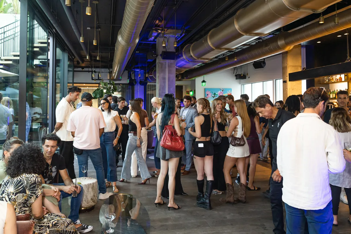 A room full of people talking in small groups at a Buffet event in Los Angeles