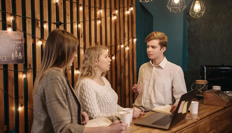 Three friends talking over coffee in a café